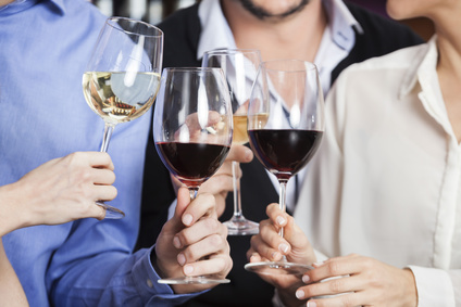 Cropped image of male and female friends toasting wine glasses in winery